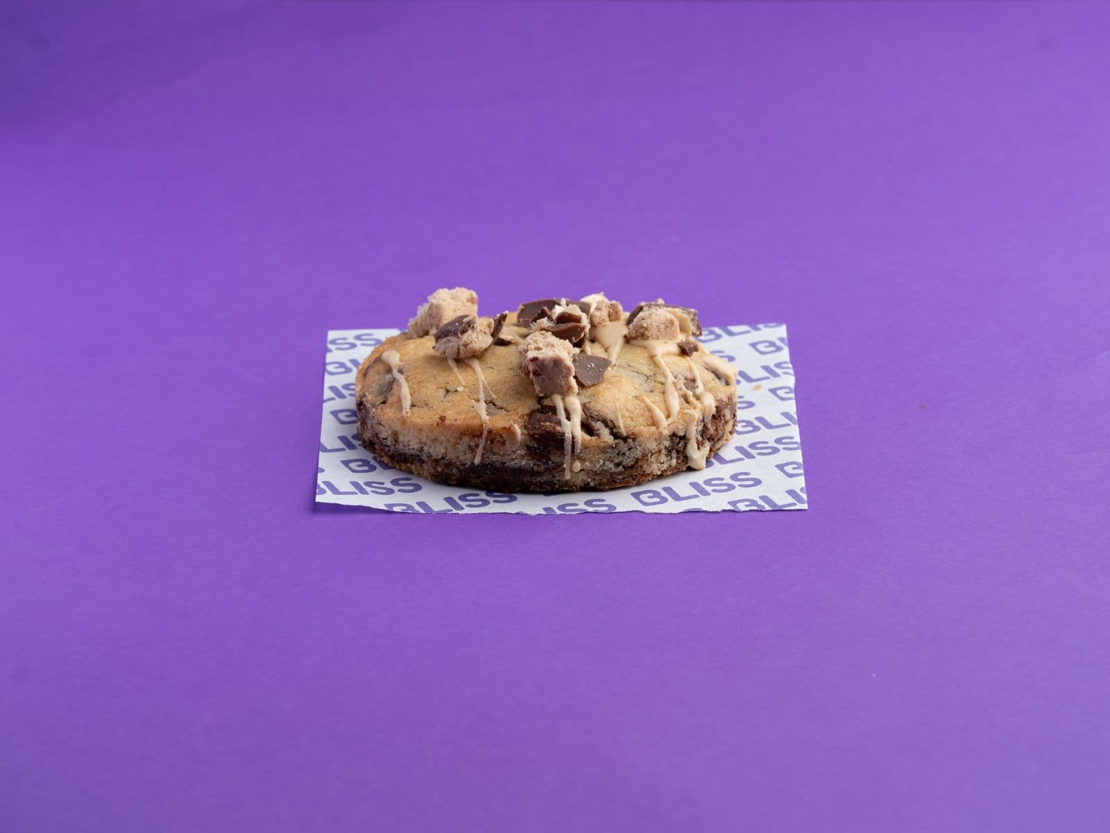La combinación que nunca falla. Una cookie de vainilla con generosos trozos de chocolate con leche, rellena con cremosa preparación sabor Bon o Bon y finalizada con un bombón en la parte superior. Cada mordida ofrece el equilibrio ideal entre chocolate, maní y una textura increíblemente suave.